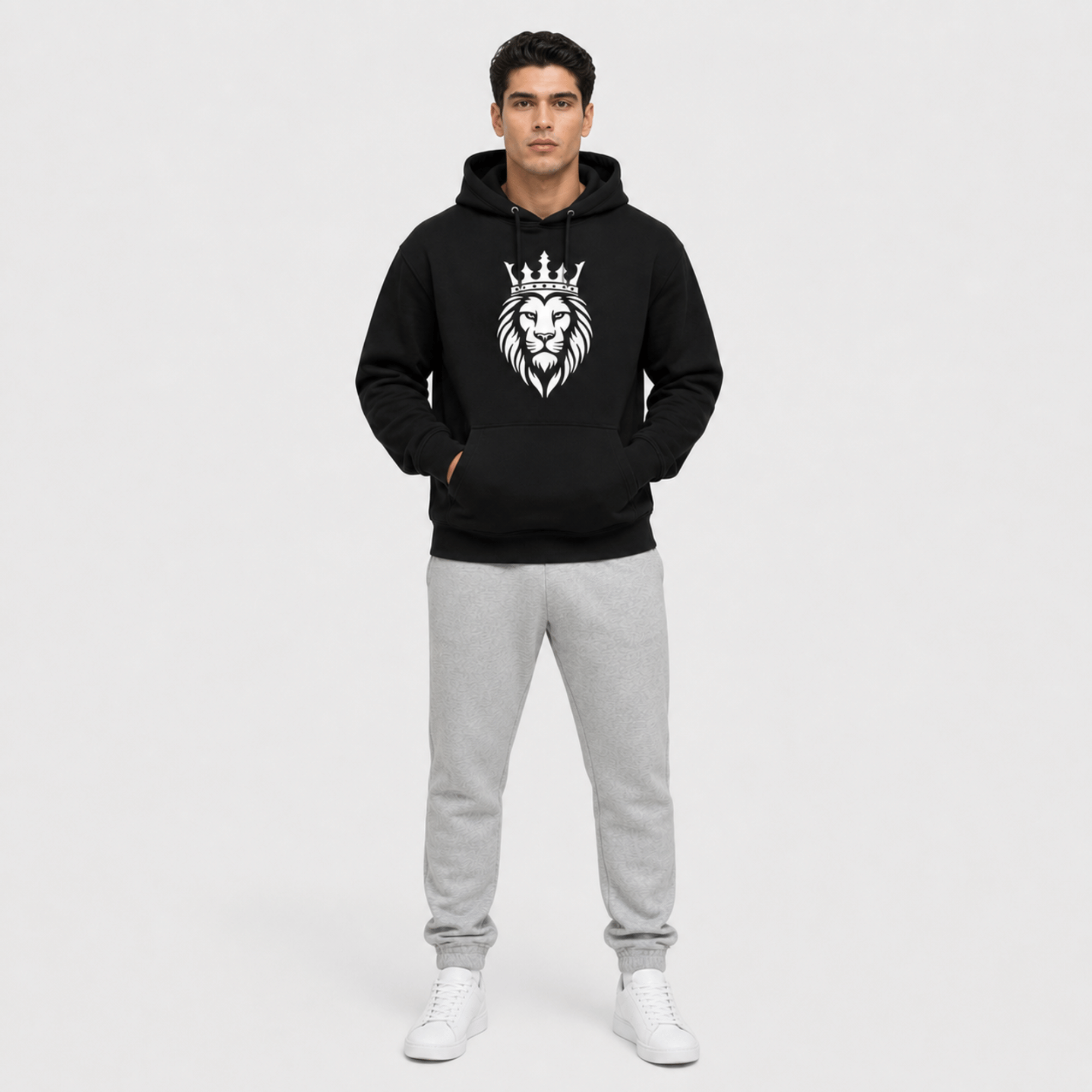 Front view of person wearing a black hoodie and gray sweatpants on a white background