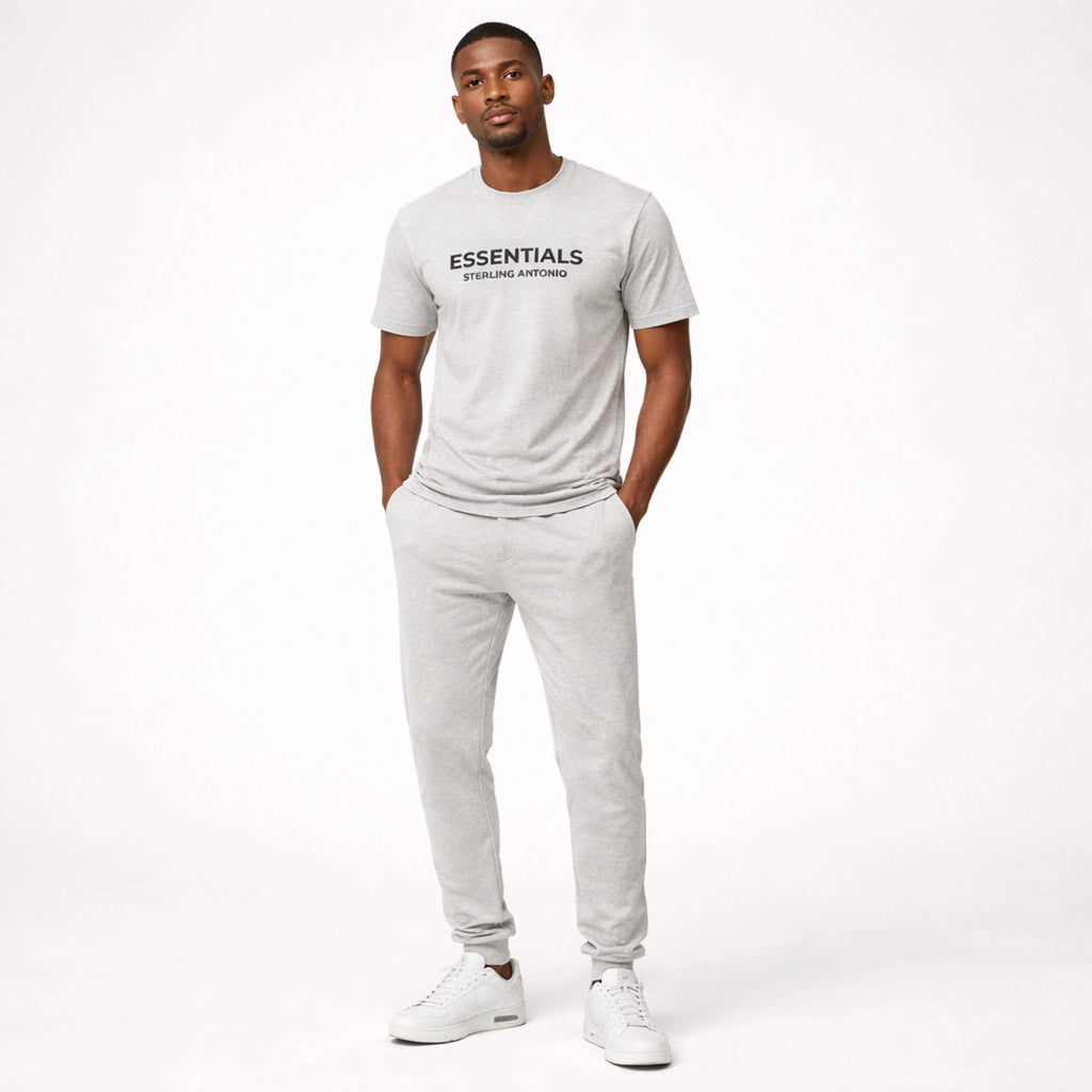 Man wearing a white 'ESSENTIALS' t-shirt and pants on a white background