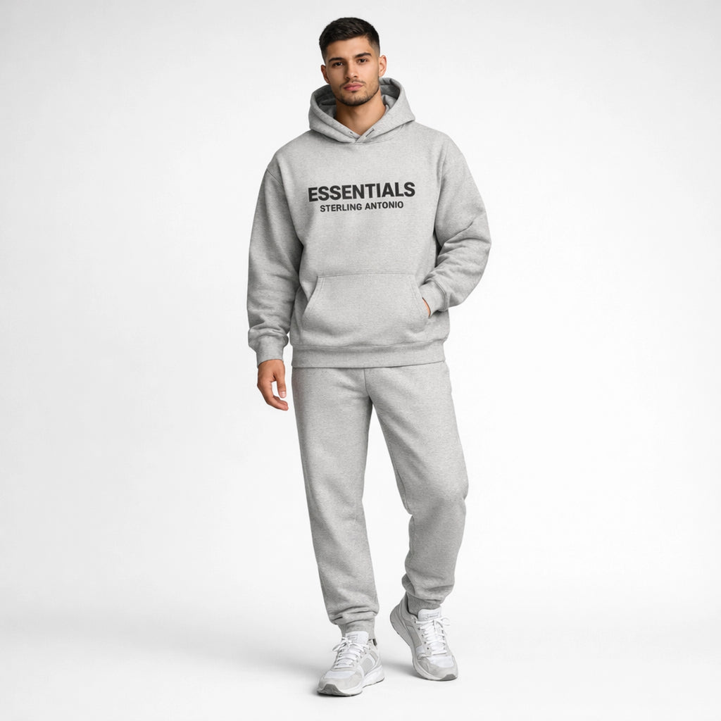 Man wearing a gray 'ESSENTIALS' hoodie and pants on a white background