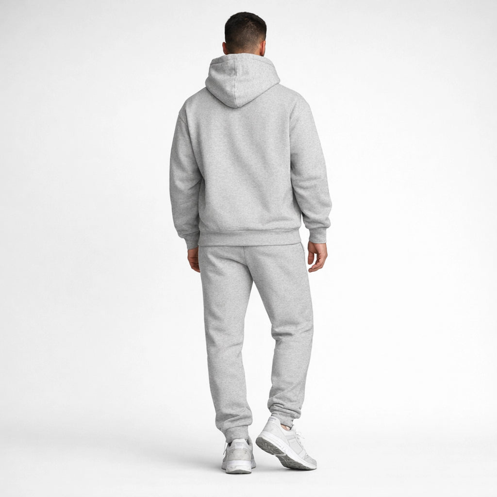 Person wearing a gray tracksuit on a white background