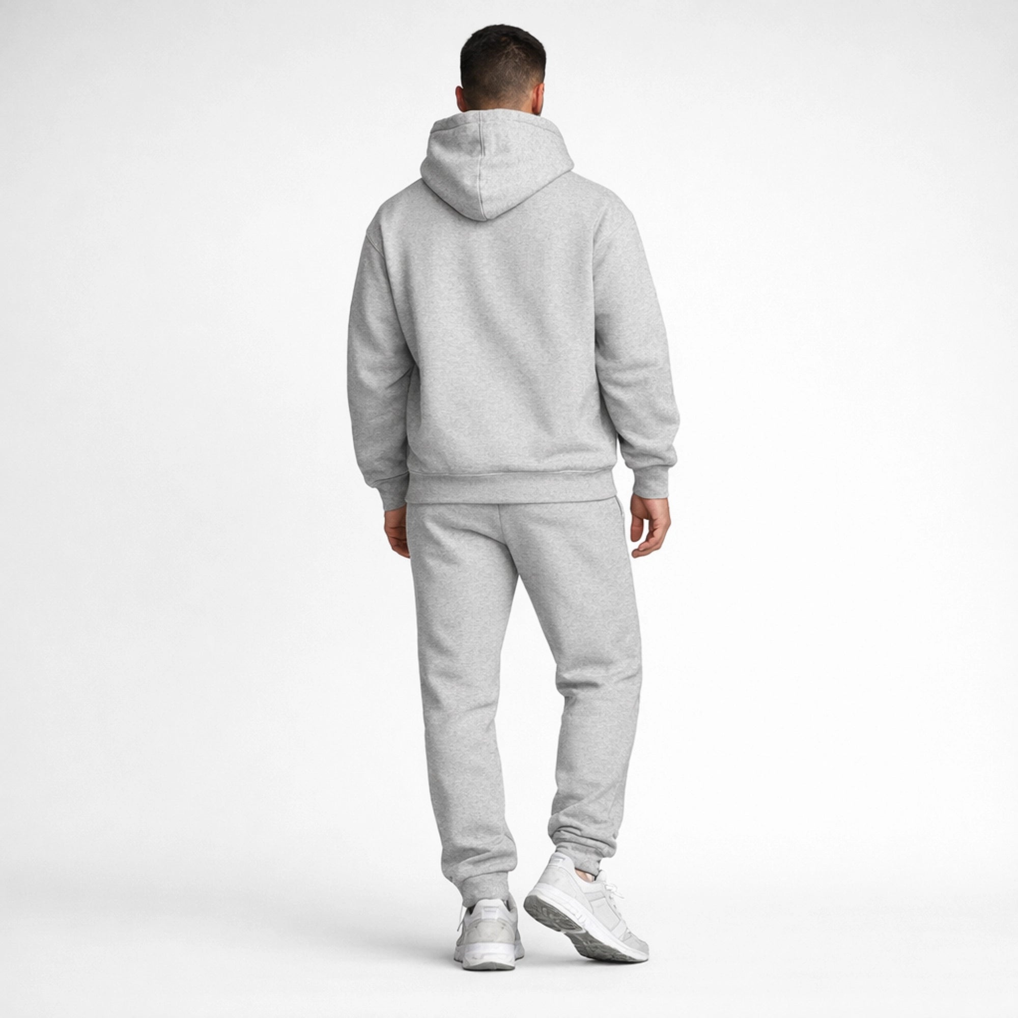 Person wearing a gray tracksuit on a white background