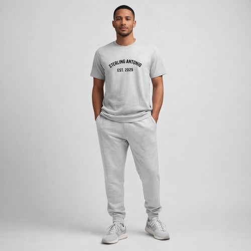 Man wearing a gray t-shirt and pants with 'Sterling Antonio' text on a plain background