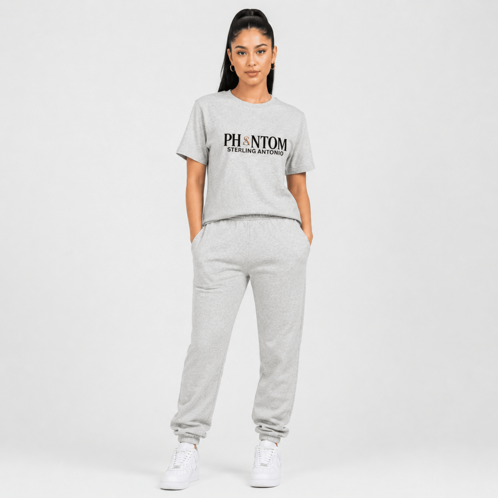 Female fashion model wearing a heather grey Phantom Sterling Antonio cotton jersey t-shirt with matching grey sweatpants and white sneakers on a light grey background