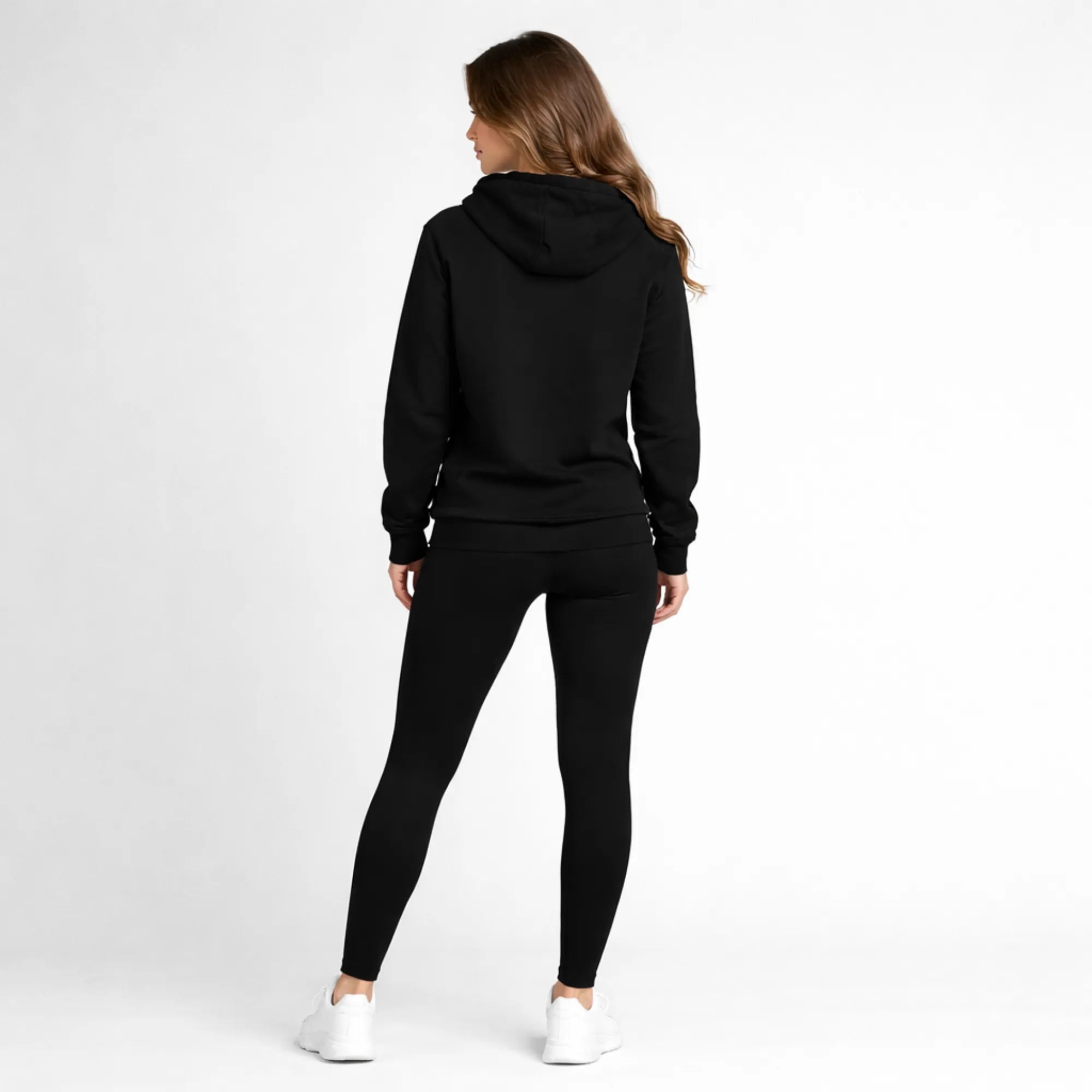 Person wearing a black hoodie and leggings set on a white background