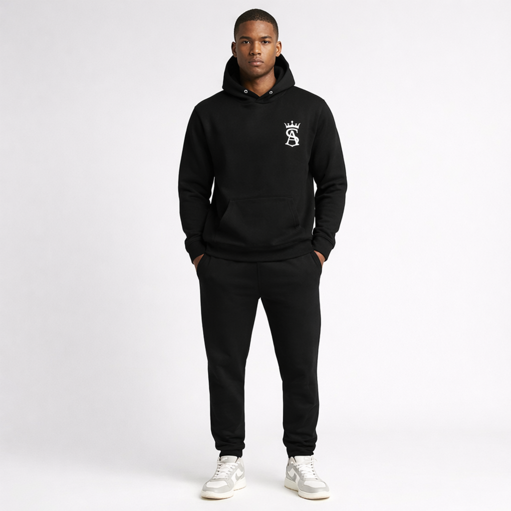 Person wearing a black hoodie and pants with a logo on a white background
