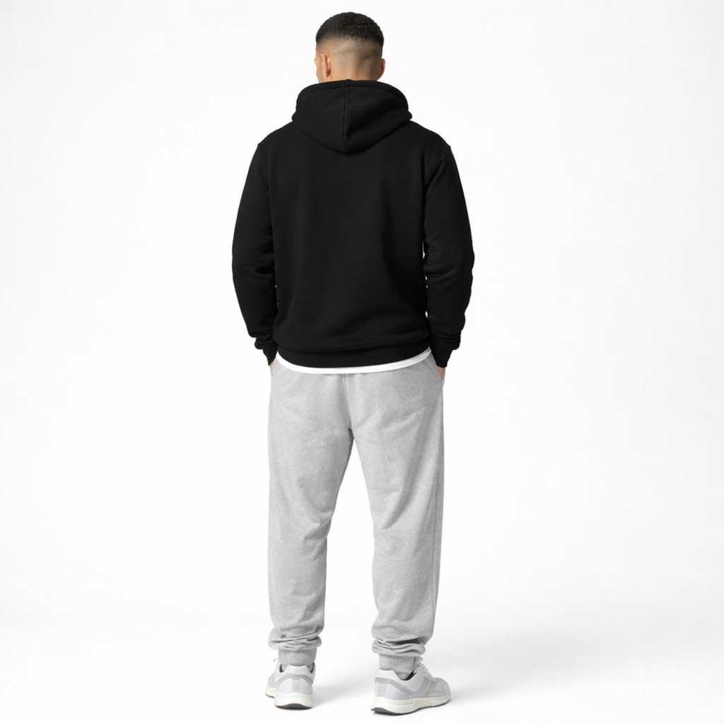 Person wearing a black hoodie and gray sweatpants on a white background