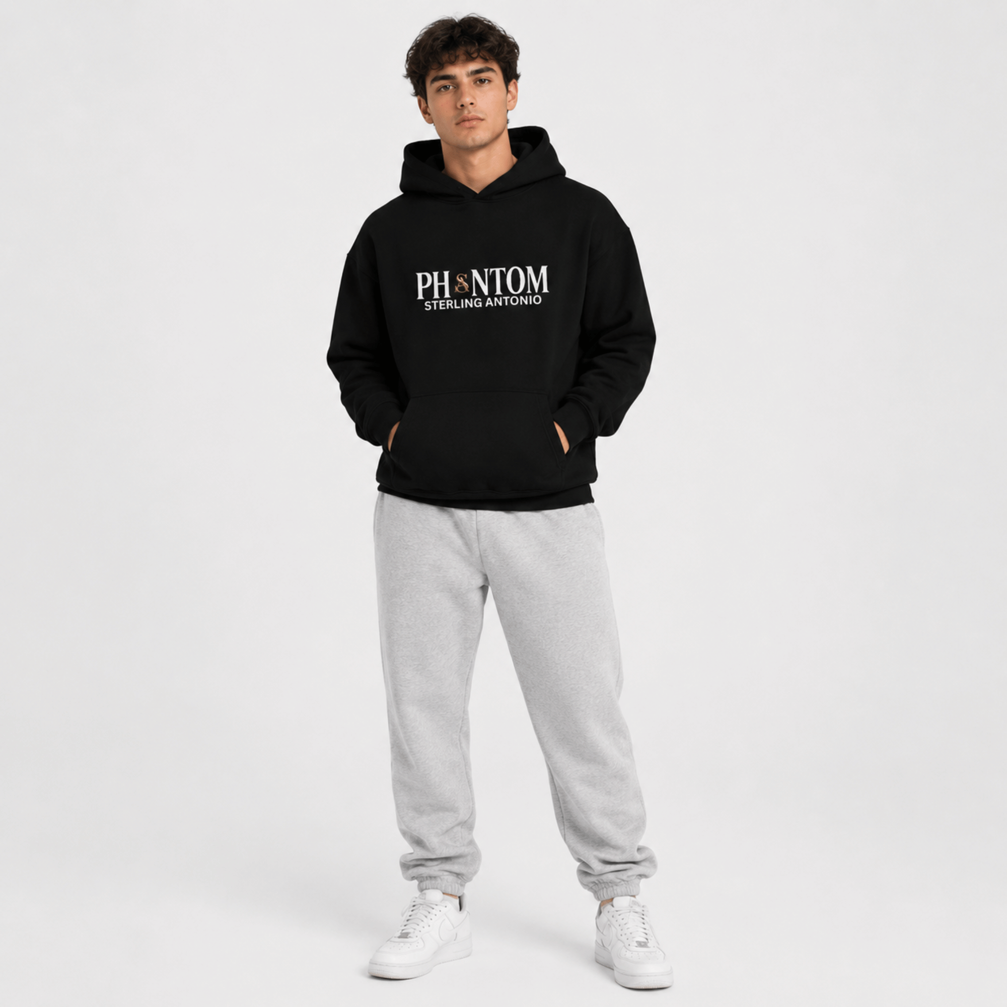 Person wearing a black hoodie with 'PHANTOM' logo and gray pants on a white background