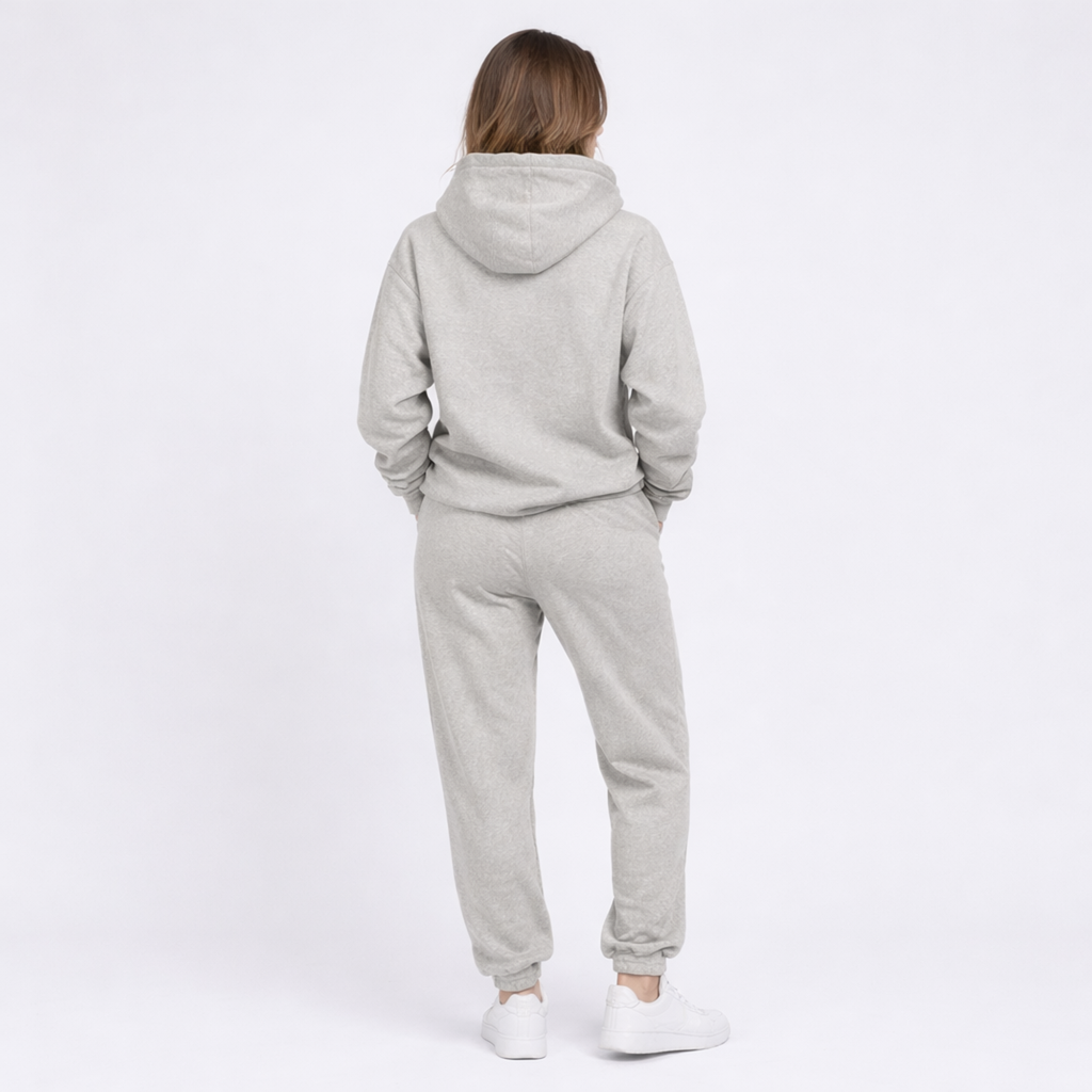 Person wearing a gray tracksuit on a white background
