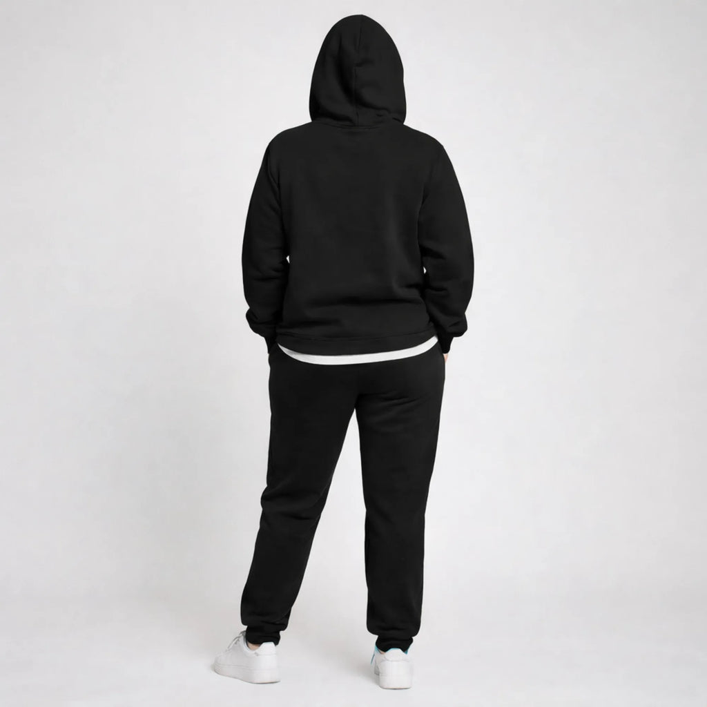 Person wearing a black hoodie and black pants on a white background