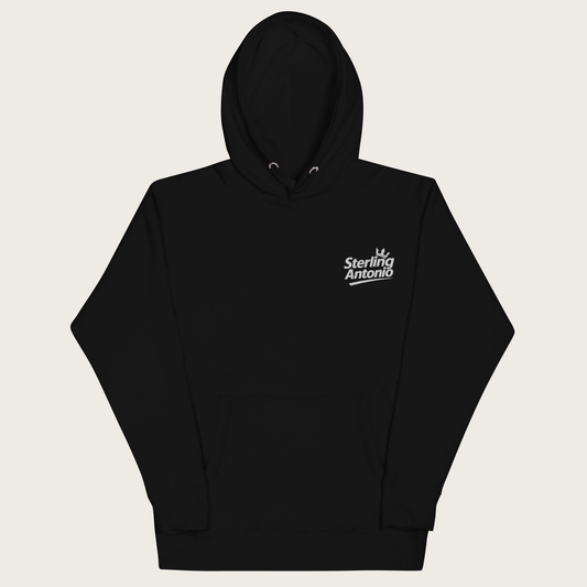 A black pullover hoodie with a small white 'Sterling Antonio' logo printed on the left chest, displayed against a light beige background.