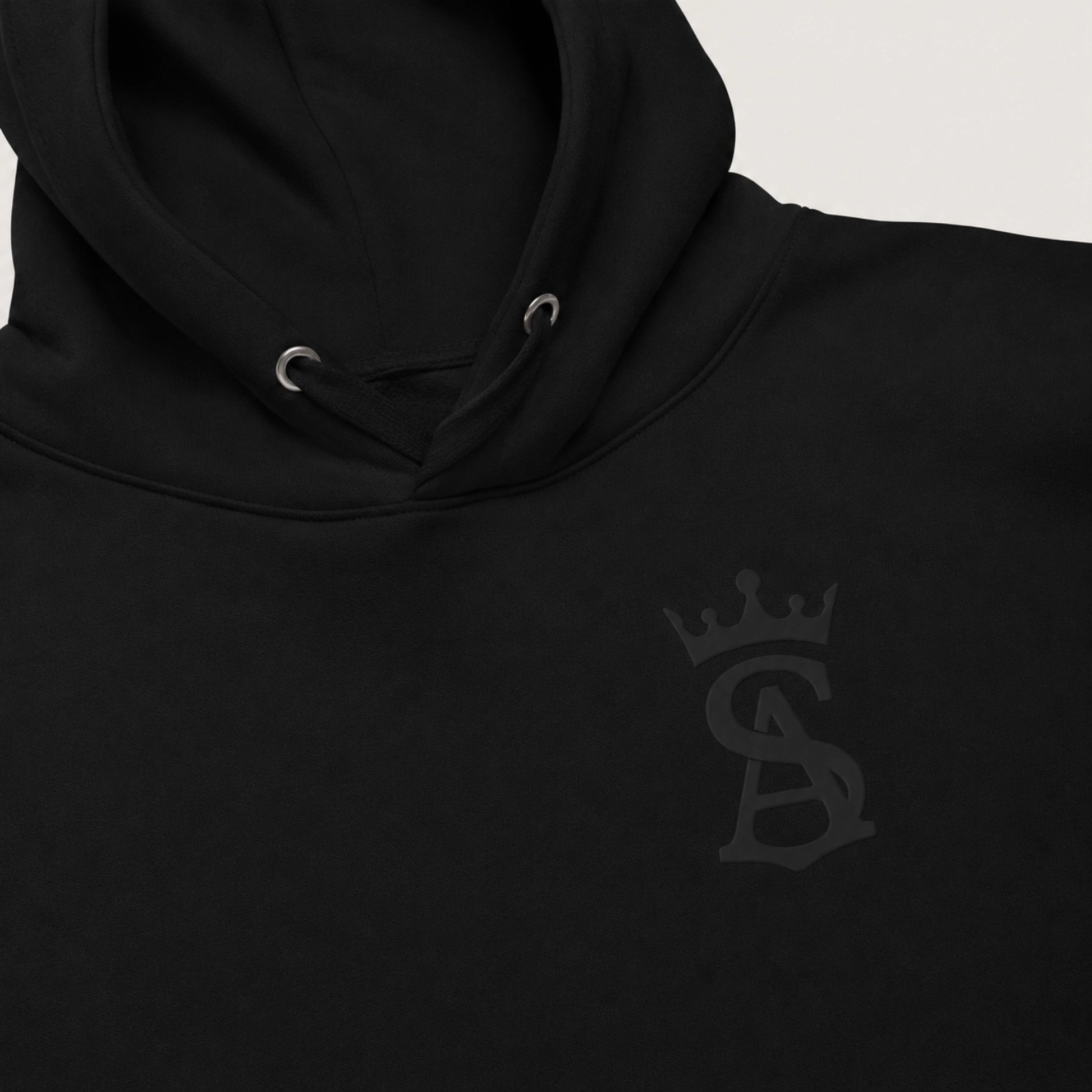 Black hoodie with a logo on the chest against a light gray background