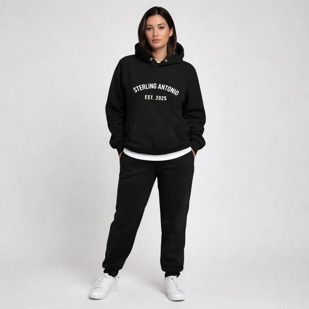 Person wearing a black hoodie and pants with 'Sterling Antonio Est. 2025' text on a white background