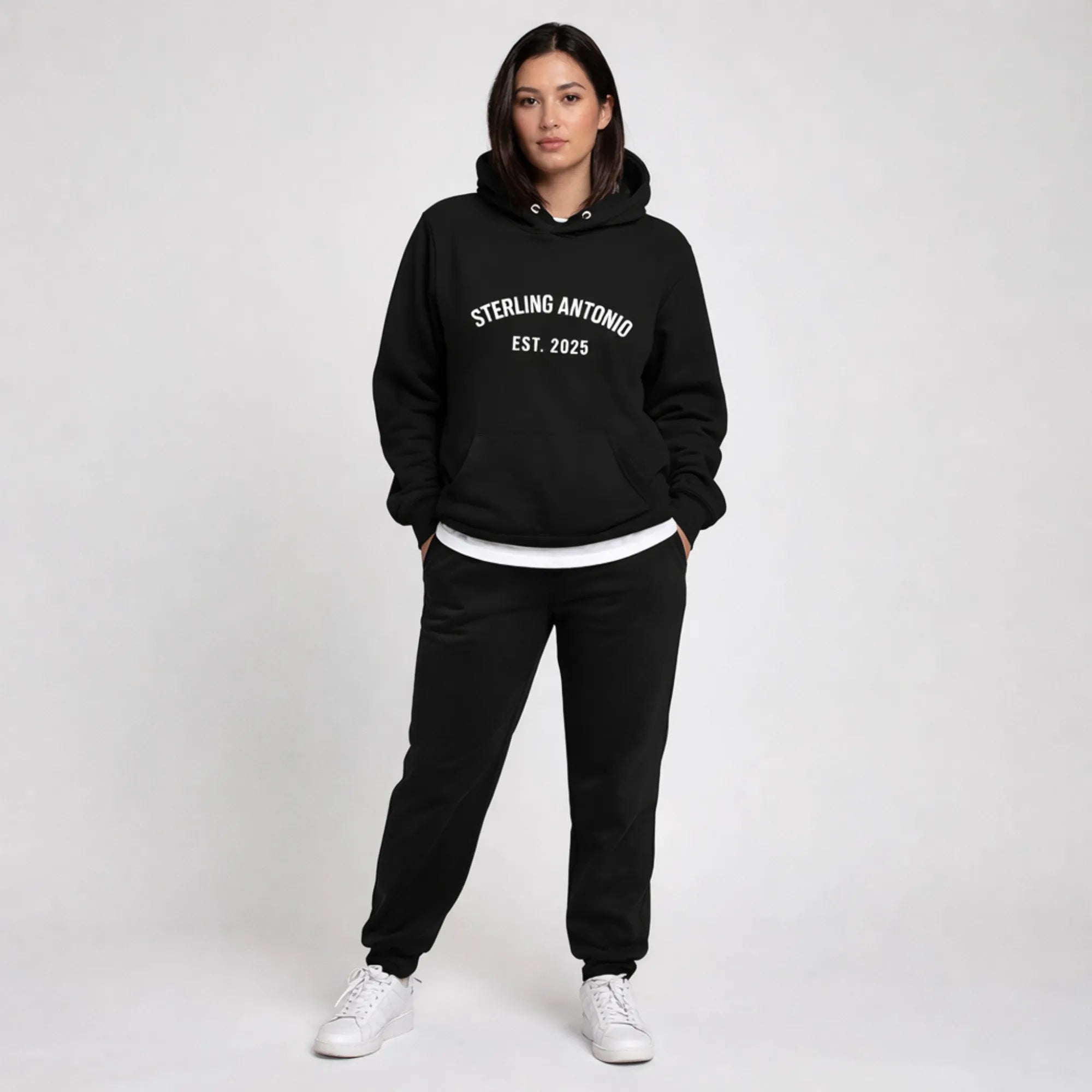 Person wearing a black hoodie and pants with 'Sterling Antonio Est. 2025' text on a white background