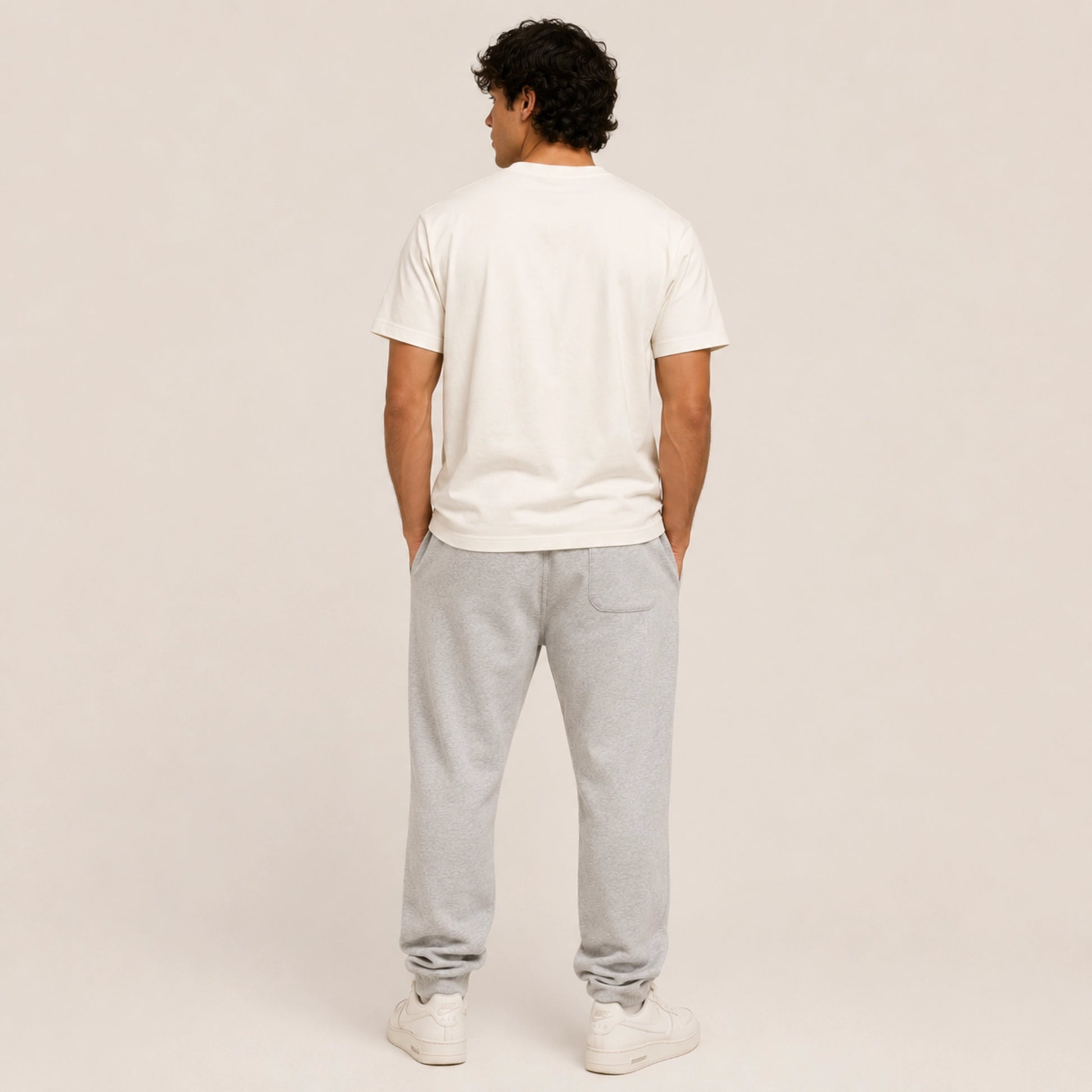 Person wearing a white t-shirt and gray sweatpants on a plain background
