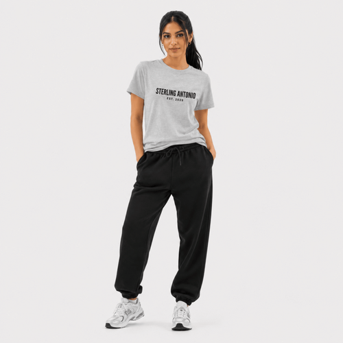 Woman wearing a gray t-shirt with 'Sterling Antonio' text and black pants on a white background