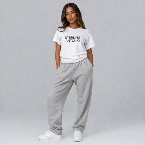 Woman wearing a white t-shirt with 'STERLING ANTONIO' text and gray sweatpants on a gray background