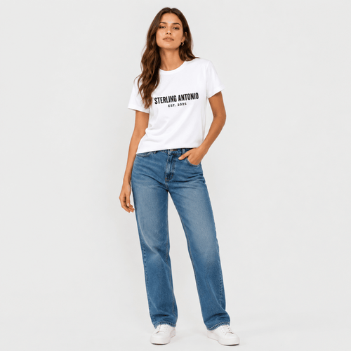 Woman wearing a white t-shirt with text and blue jeans on a plain background