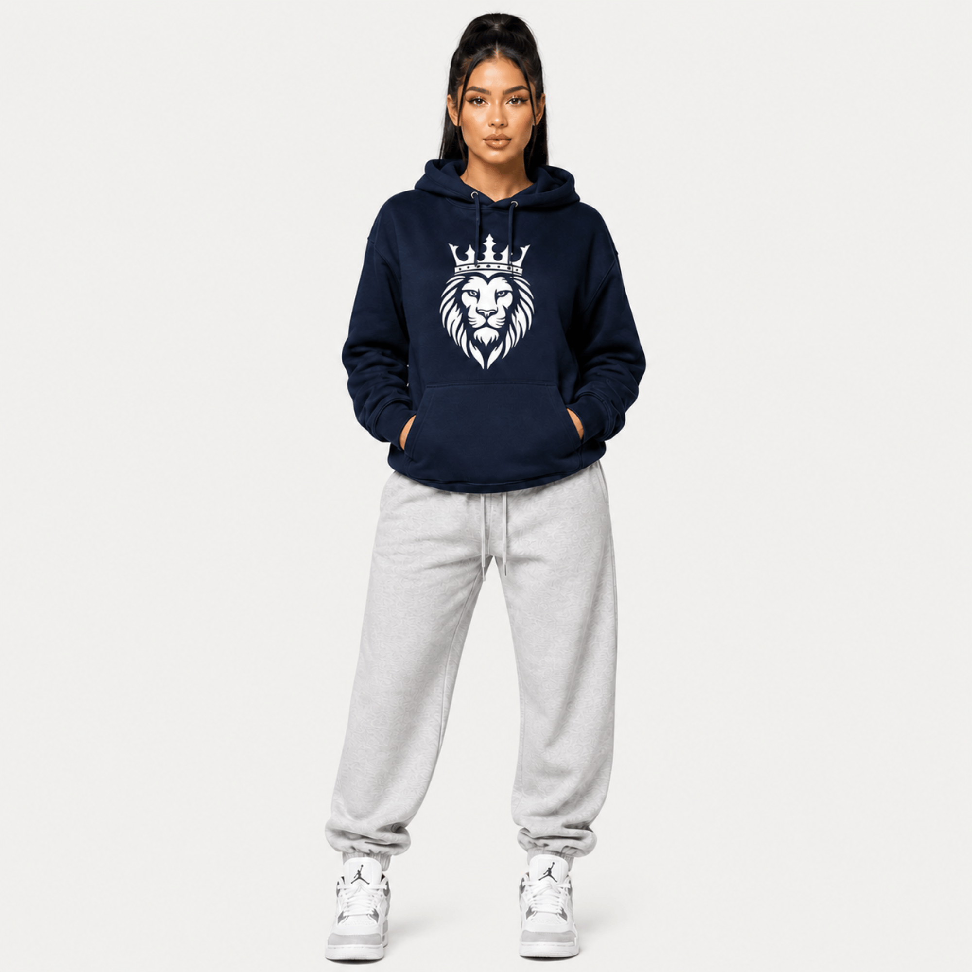Person wearing a navy hoodie with a lion emblem on a white background