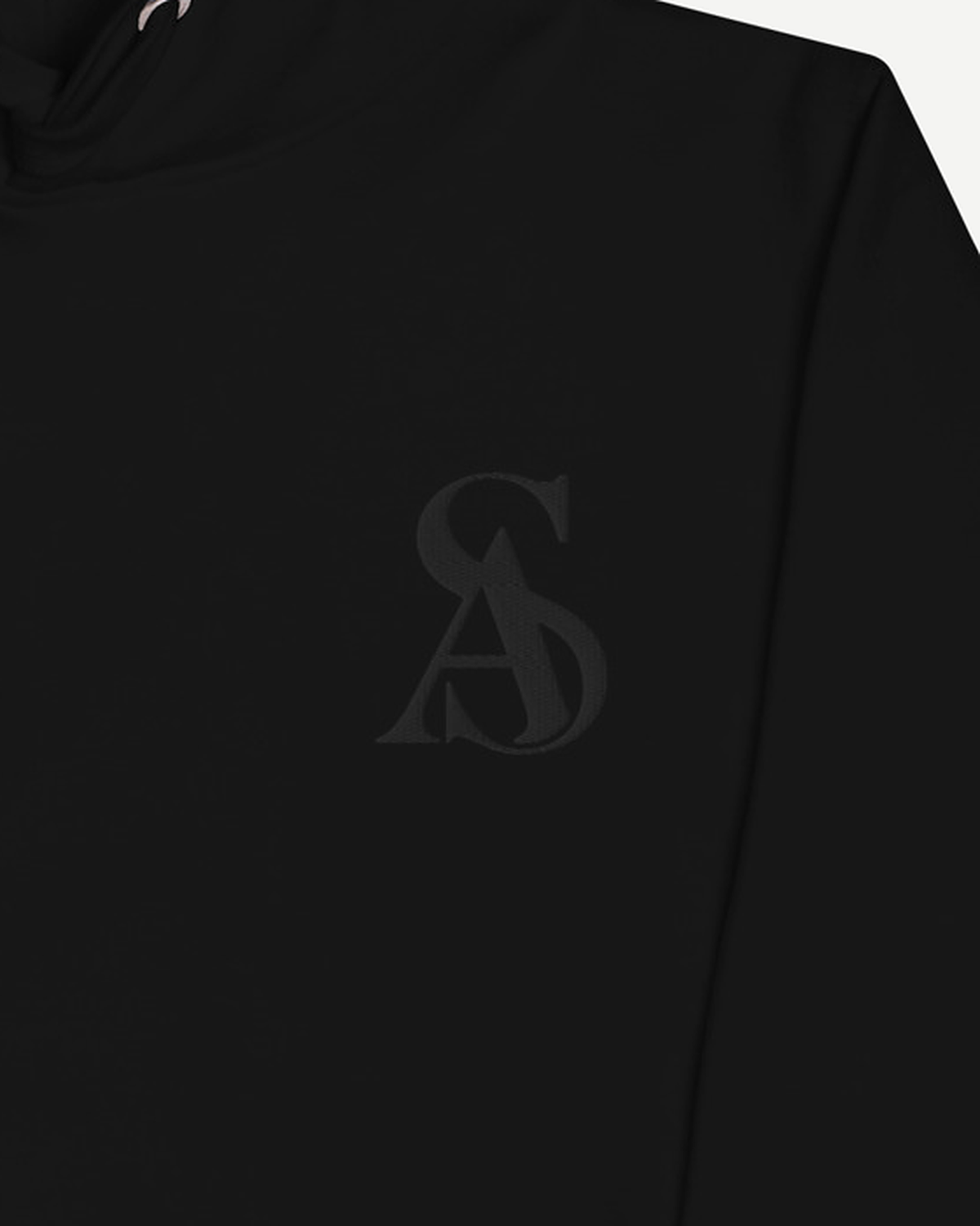 Close-up of the tonal black SA monogram embroidered at the chest of the Sterling Antonio black hoodie.
